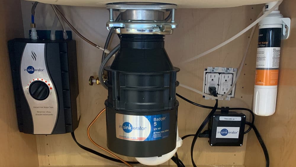 Insinkerator Badger 5 garbage disposal under sink with heating unit and water filter.