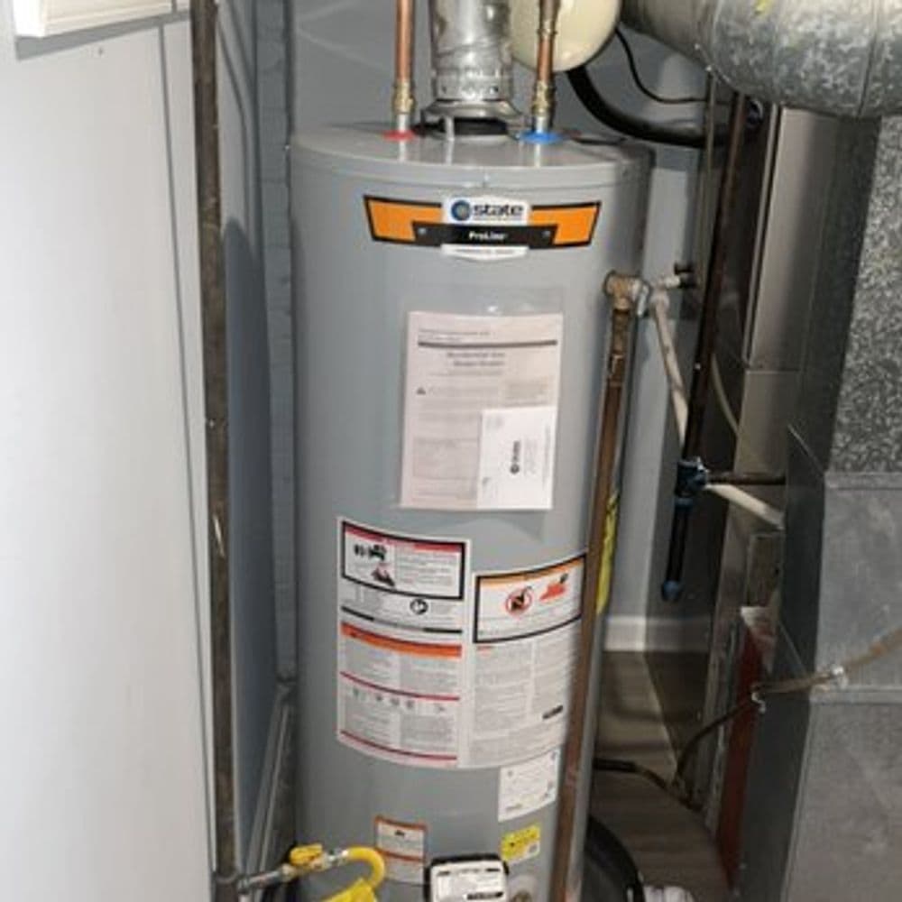 State ProLine gas water heater with safety labels and installation details visible.